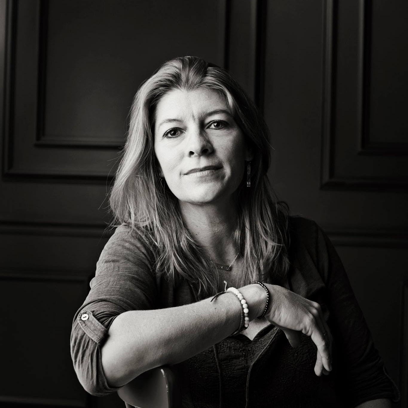A woman sitting in a chair and looking at the camera