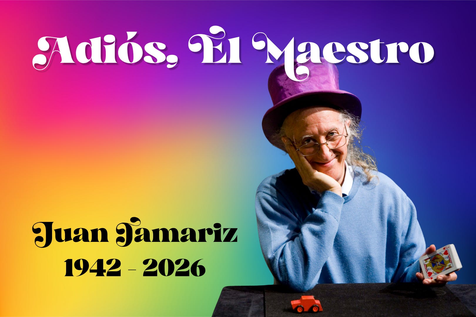 A tribute graphic for magician Juan Tamariz on a vibrant rainbow gradient background. White text at the top reads "Adiós, El Maestro", with black text reading "Juan Tamariz 1942 - 2026" in the bottom left. On the right, Tamariz smiles warmly in a large purple top hat and blue sweater, holding a deck of cards near a small red toy car. A tribute graphic for magician Juan Tamariz on a vibrant rainbow gradient background. White text at the top reads "Adiós, El Maestro", with black text reading "Juan Tamariz 1942 - 2026" in the bottom left. On the right, Tamariz smiles warmly in a large purple top hat and blue sweater, holding a deck of cards near a small red toy car.