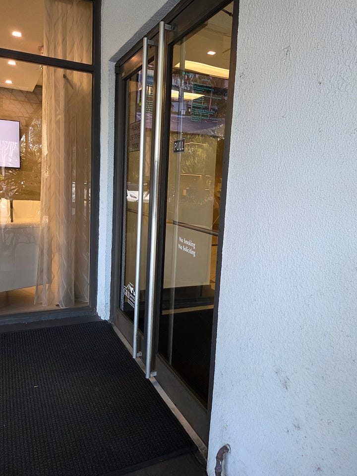 Clockwise from top left: A set of automatic, sliding doors; a set of heavy glass doors with a vertical handle the height of the door; an image of a square button with a wheelchair symbol on it that says “Press to Open”; and a set of heavy glass doors and a steel frame (painted white), with small metal handles on each.