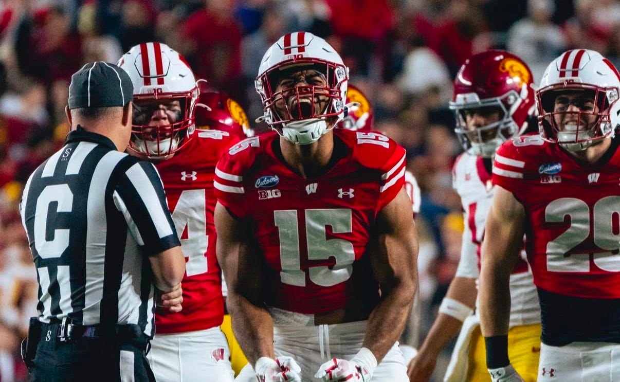 Wisconsin outside linebacker Sebastian Cheeks (15) celebrates on the field during a game against USC, surrounded by teammates and opposing players. Wisconsin outside linebacker Sebastian Cheeks (15) celebrates on the field during a game against USC, surrounded by teammates and opposing players.