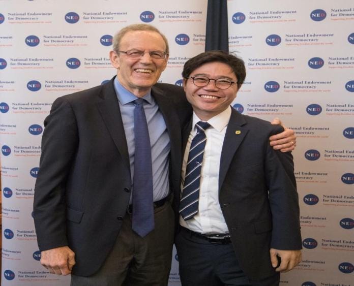 A couple of men posing for a picture

Description automatically generated with low confidence