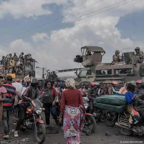 A group of people on motorcycles next to soldiers sitting on a military tank A group of people on motorcycles next to soldiers sitting on a military tank