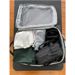 A macpac suitcase outside and packed inside view showing folded clothes and washbag