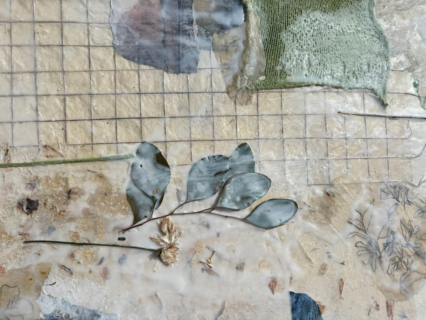 Mixed-media artwork with embedded leaves, fabric, stitching, and translucent layered textures. Mixed-media artwork with embedded leaves, fabric, stitching, and translucent layered textures.