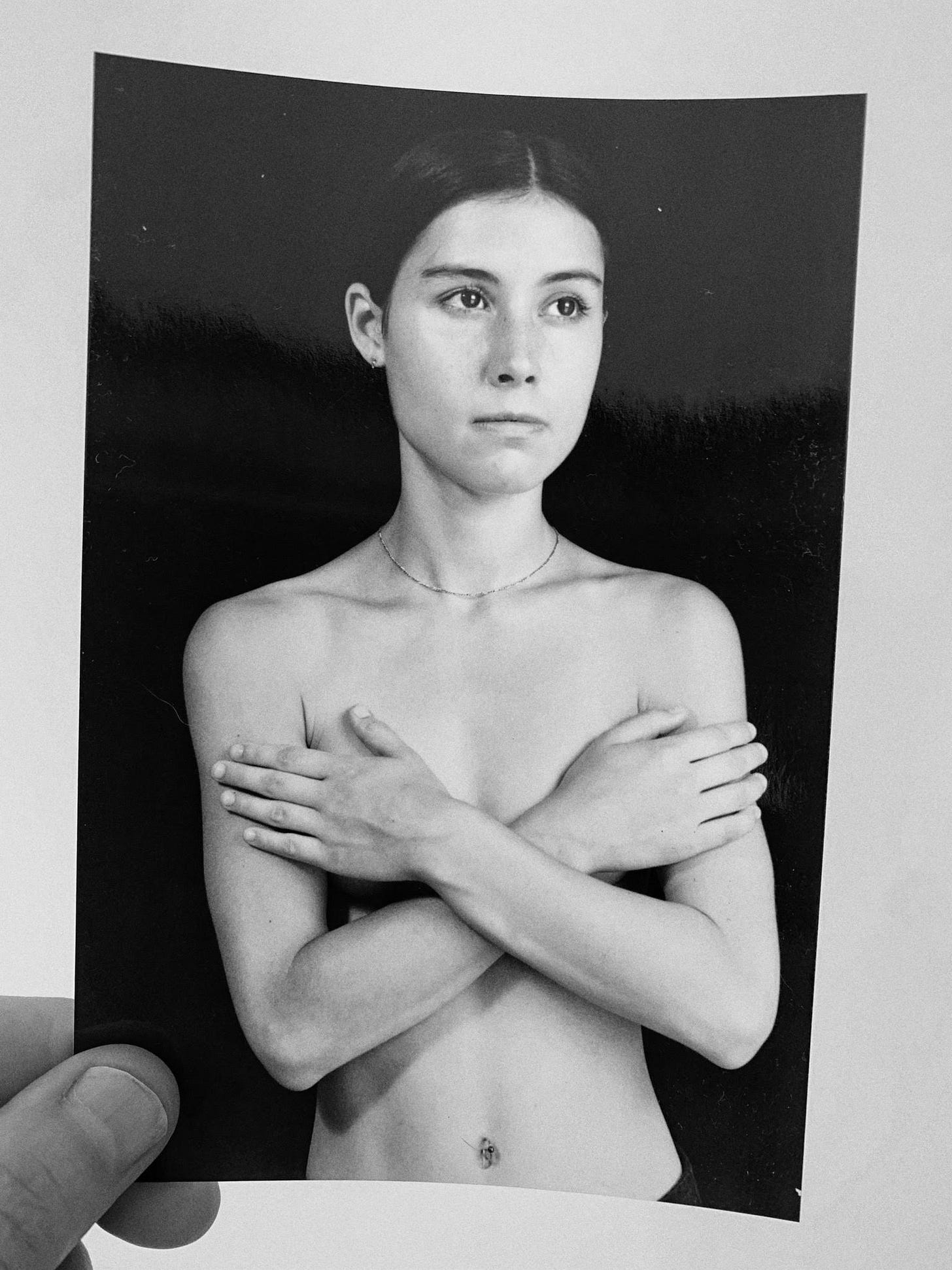 Black-and-white image of author in her 20s, unclothed, crossing arms over chest, looking serious, maybe angry