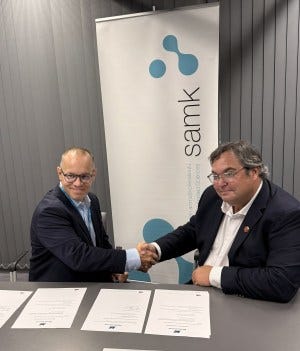 Two men, both heads of schools, shake hands.