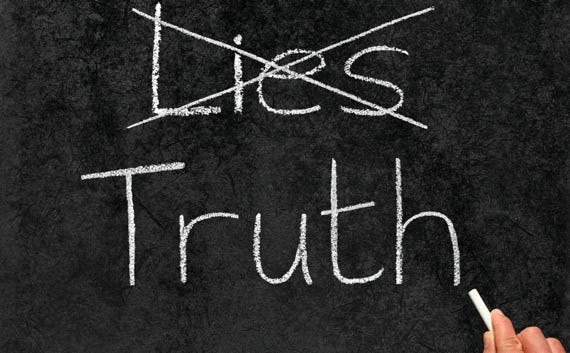 Crossing out Lies and writing Truth on a blackboard.
