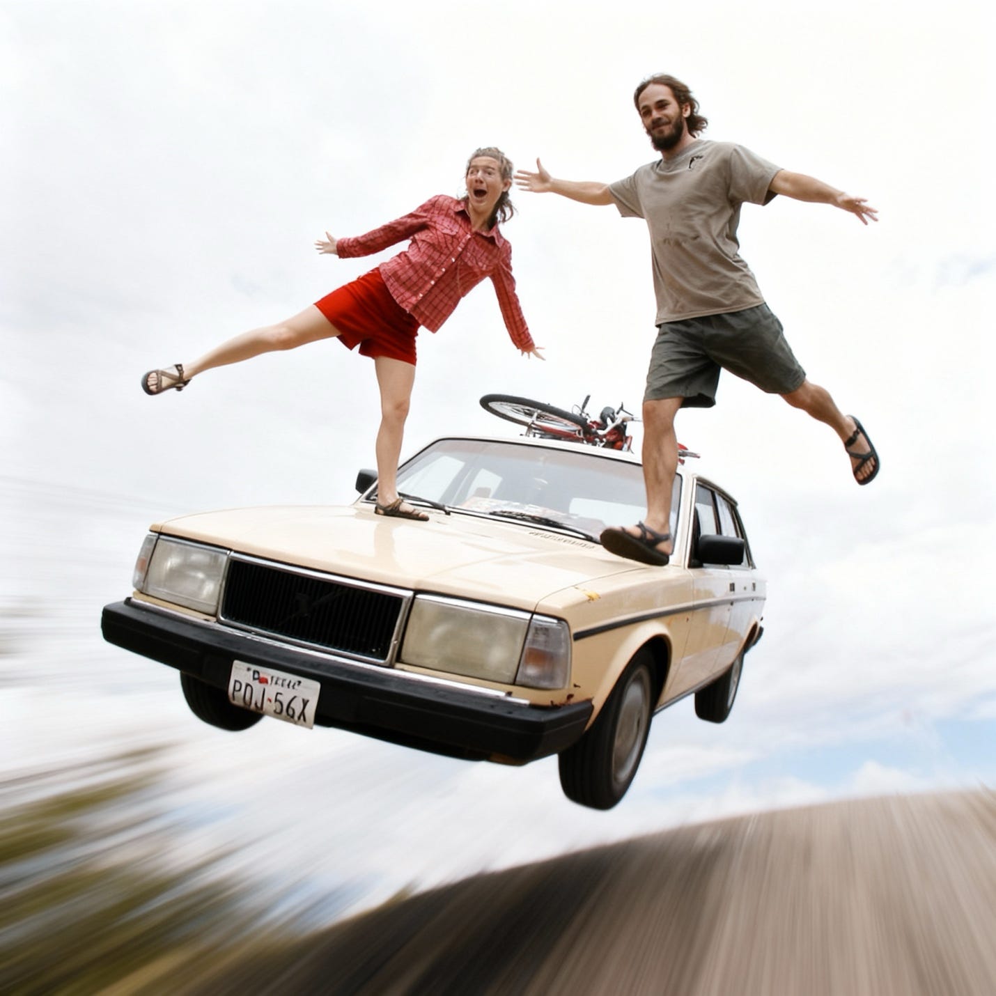 A couple performs a daredevil stunt on a fast moving car flying through the air