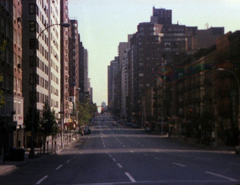 A street with buildings in the background

Description automatically generated