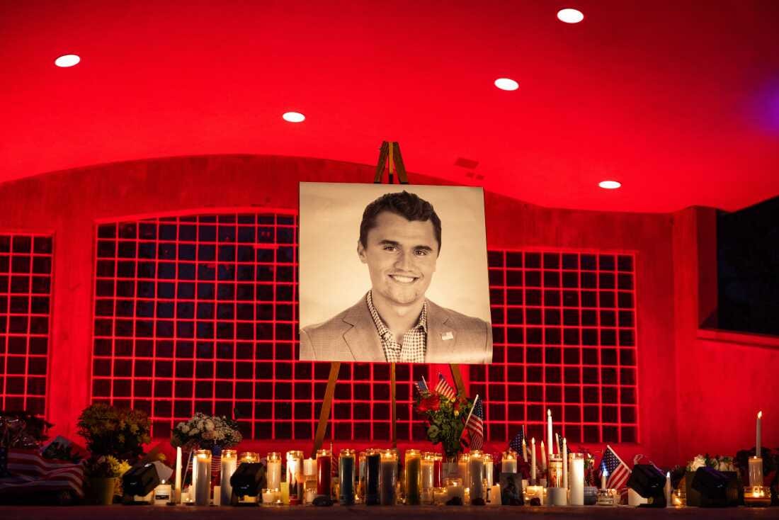 A large black and white photo of Charlie Kirk, 31, is seen at his makeshift memorial at Orem City Center Park in Orem, Utah. The area is lit with red lights and there are dozens of lit candles underneath the photo along with a few American flags and flower bouquets. A large black and white photo of Charlie Kirk, 31, is seen at his makeshift memorial at Orem City Center Park in Orem, Utah. The area is lit with red lights and there are dozens of lit candles underneath the photo along with a few American flags and flower bouquets.