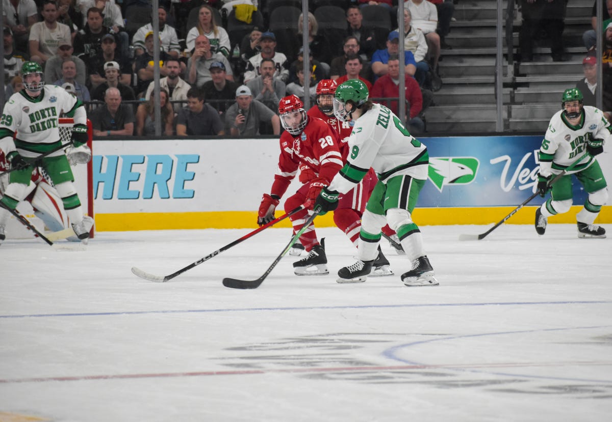 North Dakota hockey player Will Zellers looks to shoot the puck near the top of the zone
