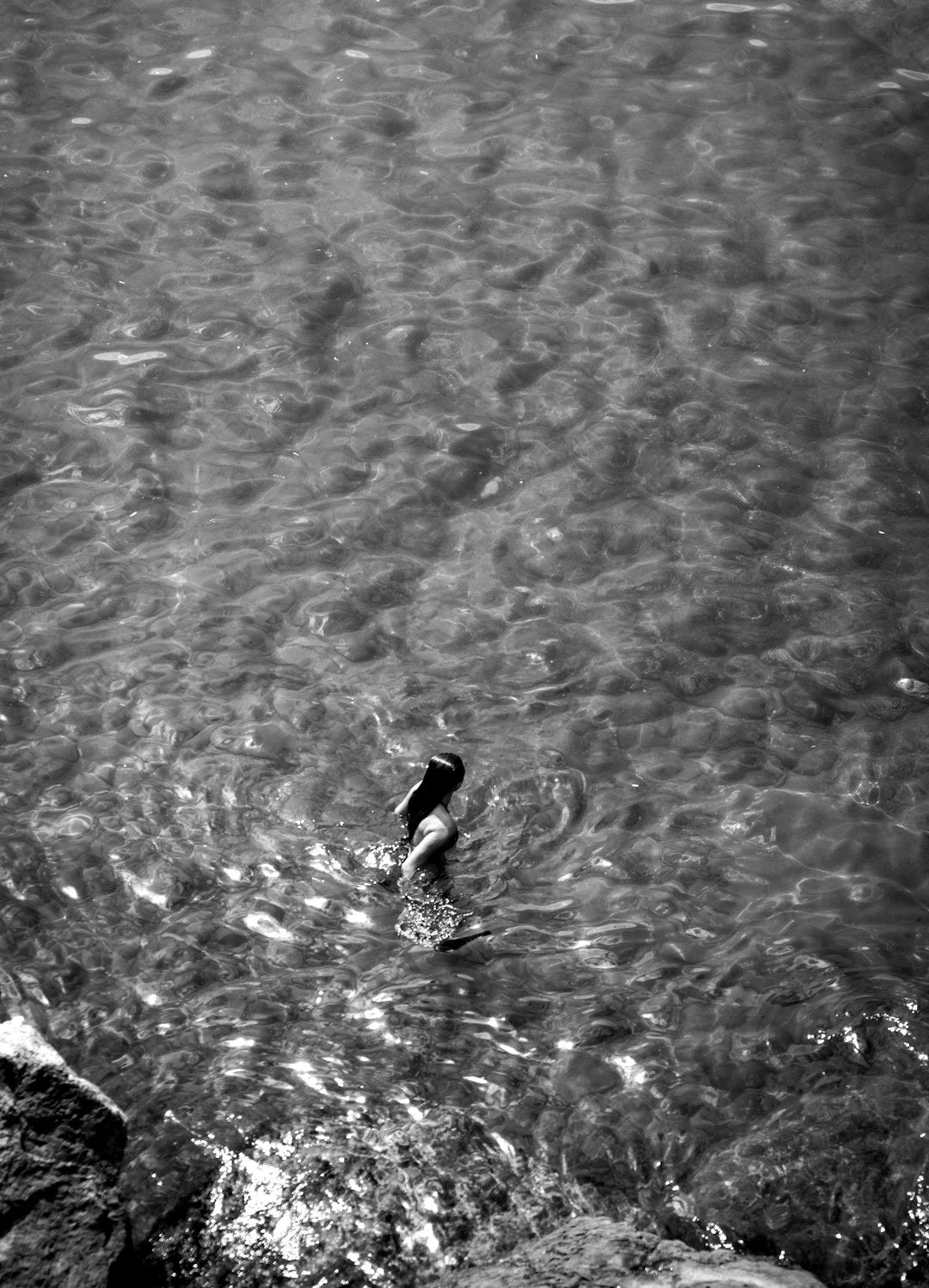 aerial photo of woman swimming on clear water