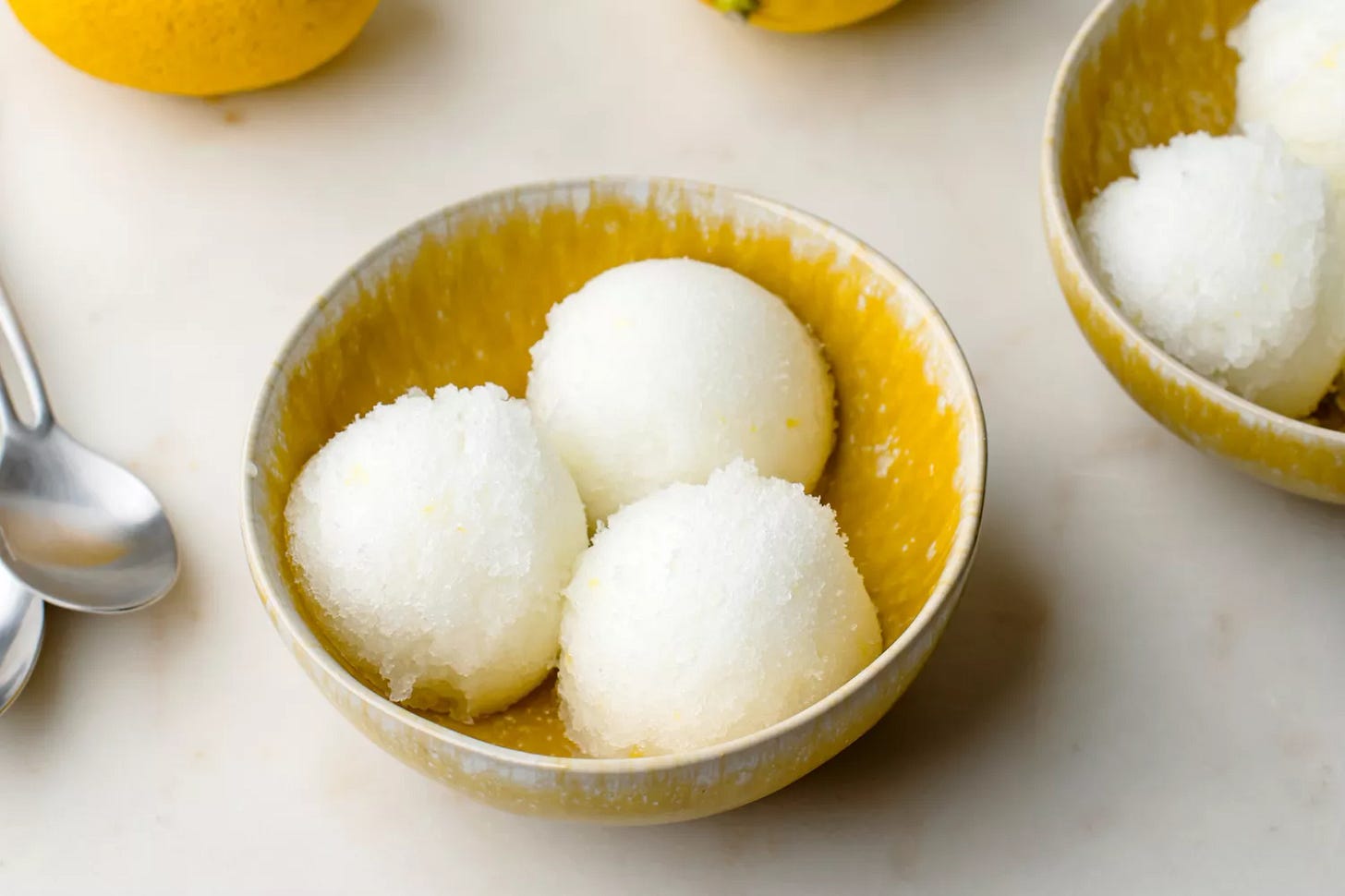 Lemon Italian ice scooped into yellow bowls