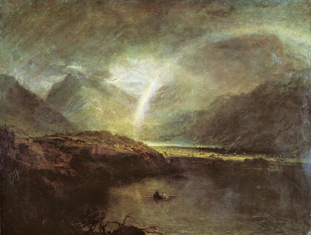 A pale rainbow arcs over a still dark lake among rain soaked English mountains A pale rainbow arcs over a still dark lake among rain soaked English mountains