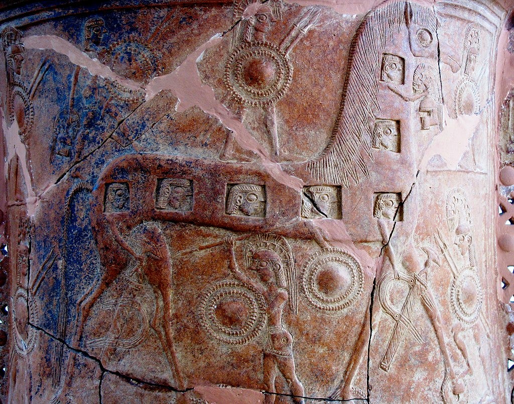 Image of the Mykonos vase with a version of the Trojan Horse that has cut out windows to show the warriors inside Image of the Mykonos vase with a version of the Trojan Horse that has cut out windows to show the warriors inside