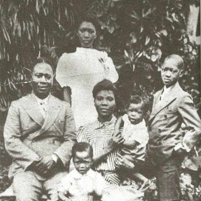 A weathered black and white photograph of a Nigerian family