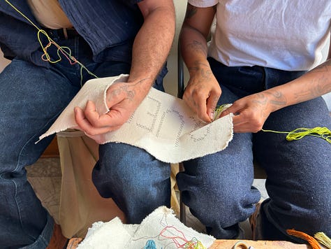 hands working with fiber and canvas spelling out words: Forgive, Freedom, Queer