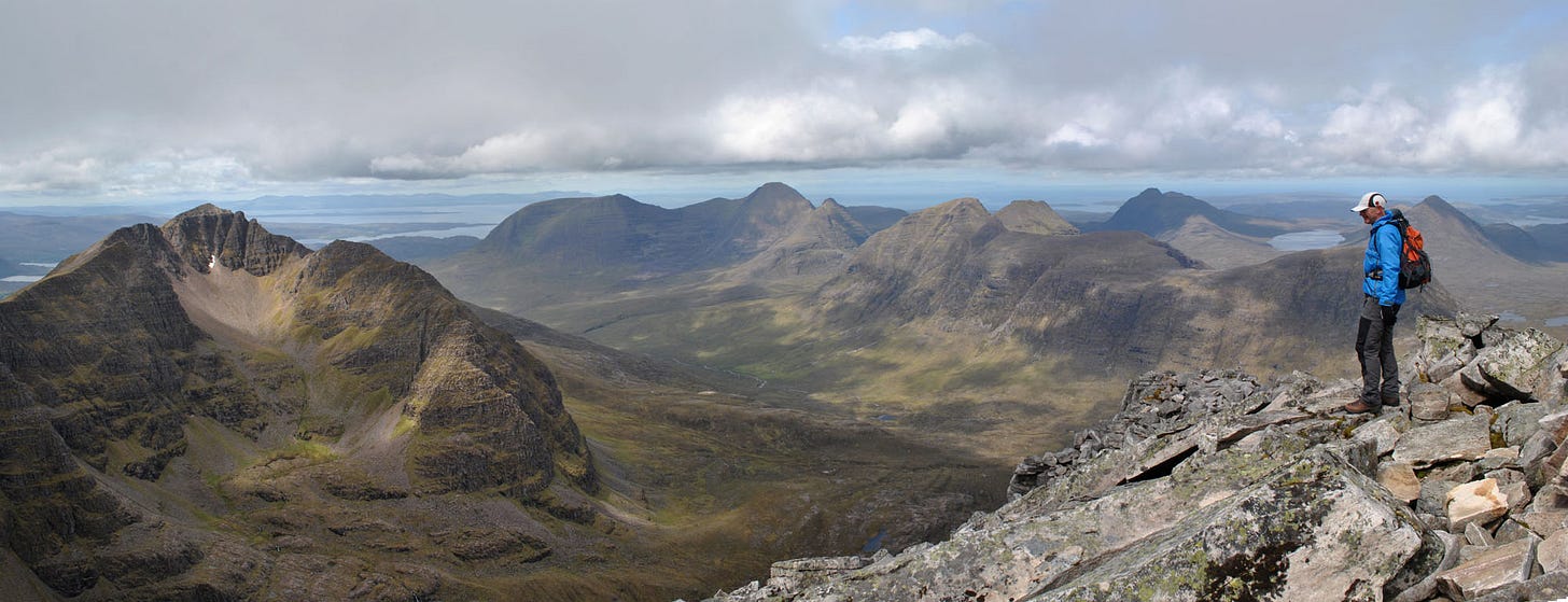 man on mountaintop, distant sea