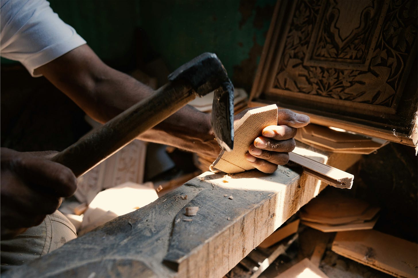 a craftsman holding his tool and a piece of wood