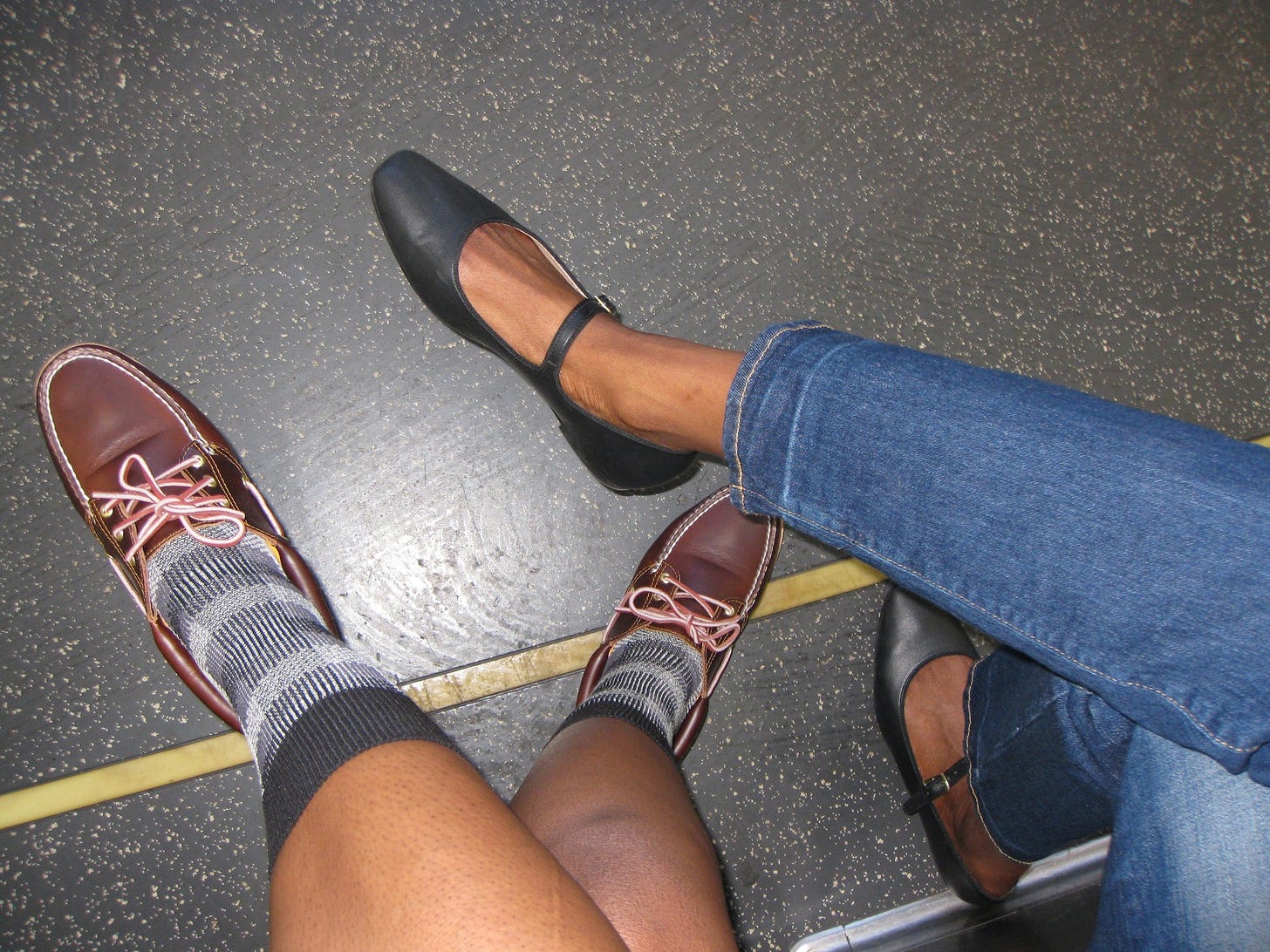 A photo of my sister's boat shoes and my flats on the floor of the train, taken from above..