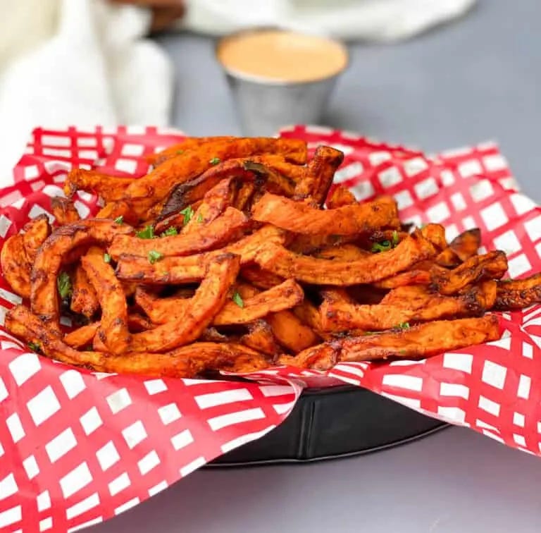 air fryer sweet potato fries in a basket with a red and white napkin air fryer sweet potato fries in a basket with a red and white napkin