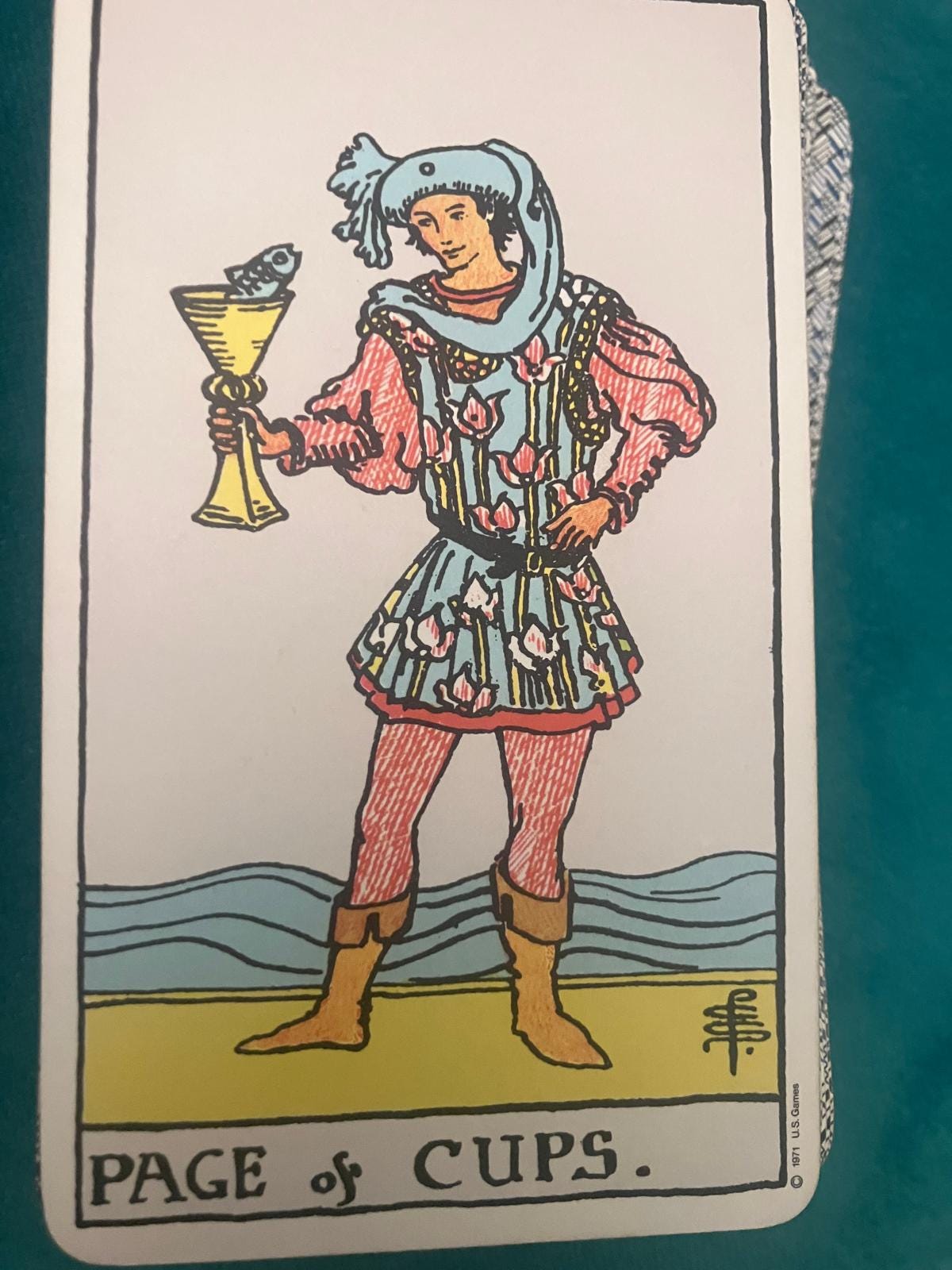 Page of Cups tarot card from Jill Dawson’s Tarot DMs Chat 42, showing a figure holding a golden cup with a fish emerging from it.