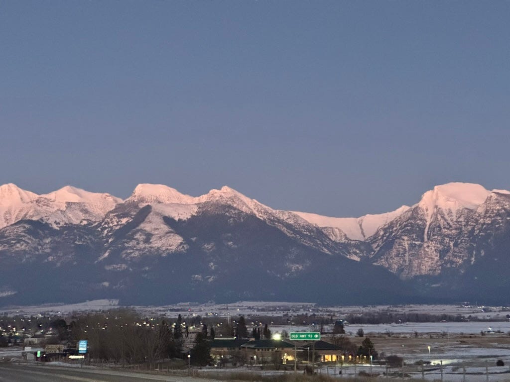 A road with snowy mountains in the background

Description automatically generated
