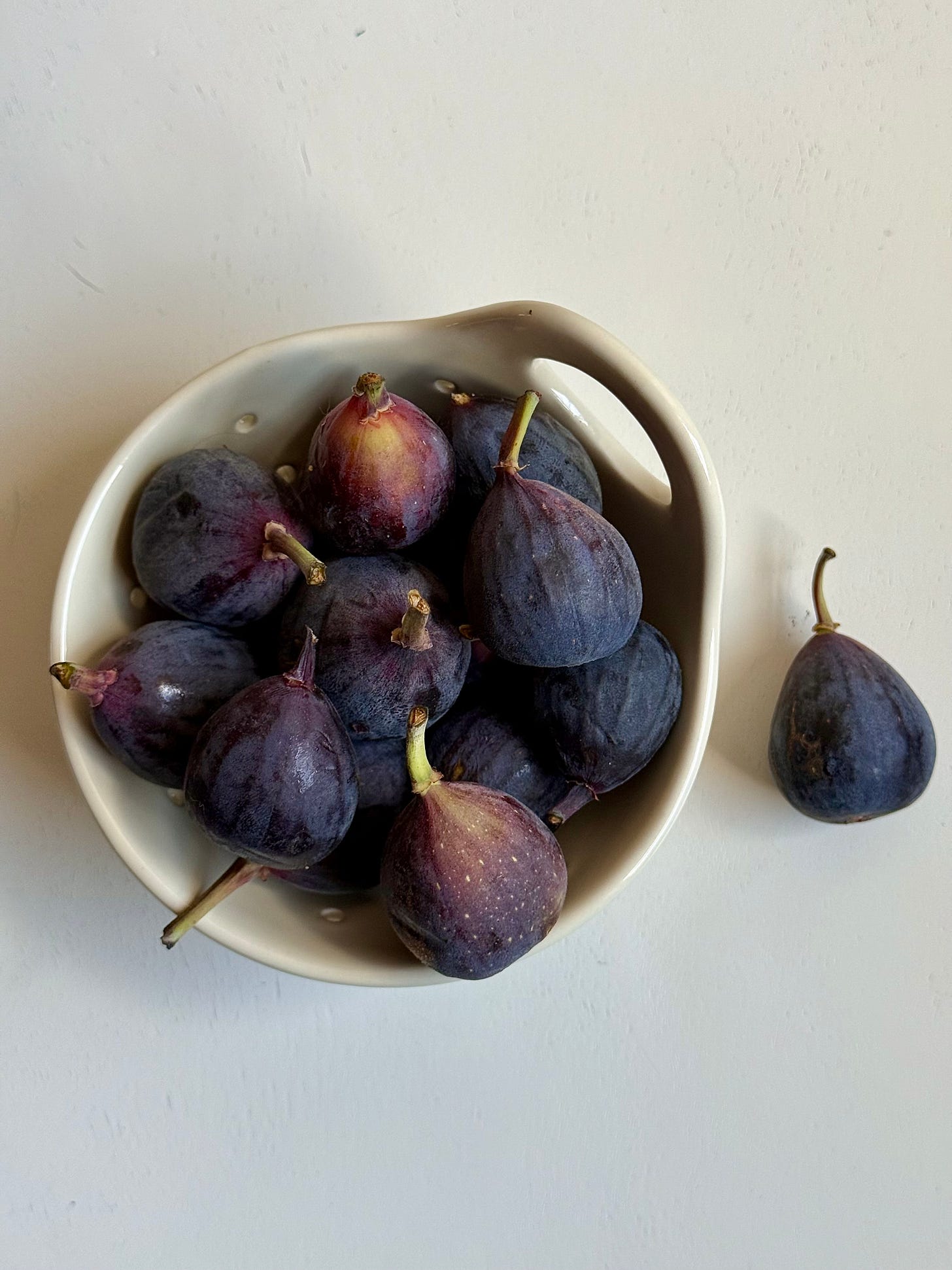 A small bowl of figs on a white table, Studio Delicous.com 