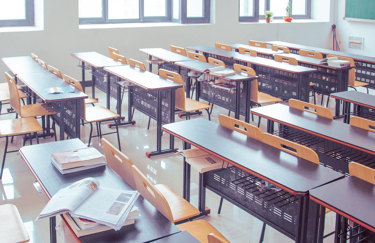 A tidy unoccupied classroom with chairs and a few textbooks, bright and light all around A tidy unoccupied classroom with chairs and a few textbooks, bright and light all around