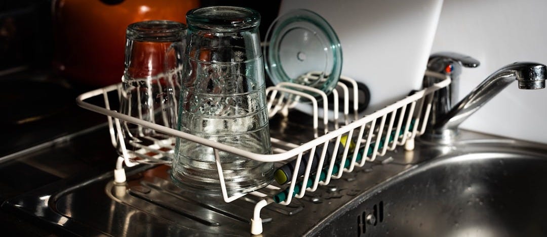 clear glass mugs on white metal rack