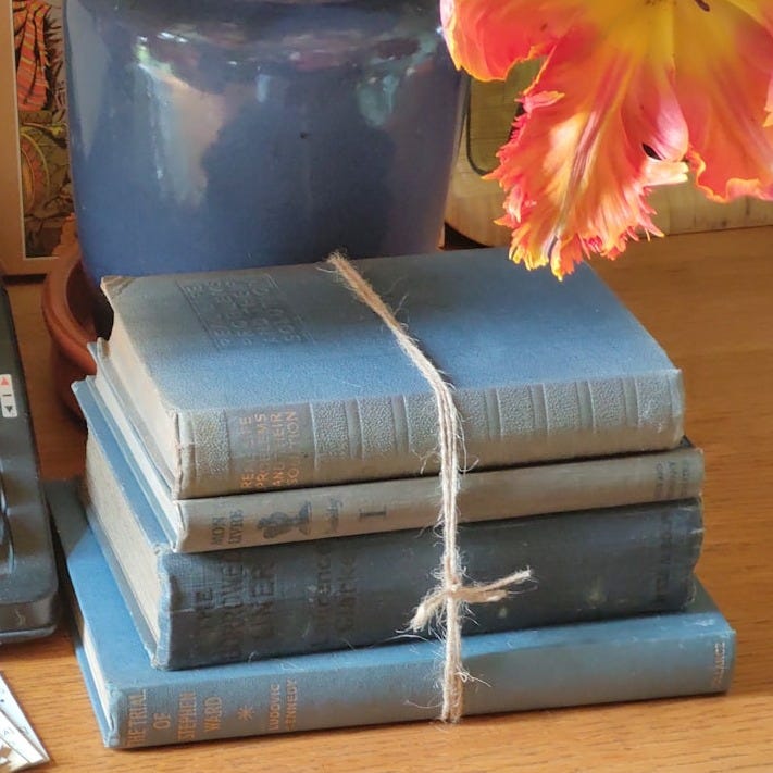 a stack of books sitting on top of a table next to a typewriter