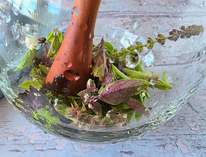 muddling the aromatics, then adding and stirring the liquids for the drink base