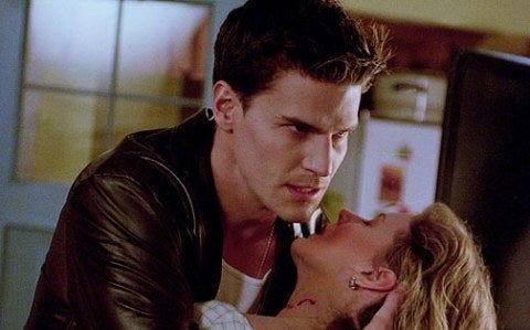 a still from buffy the vampire slayer where angel is holding a woman with bite marks in her neck, looking distraught