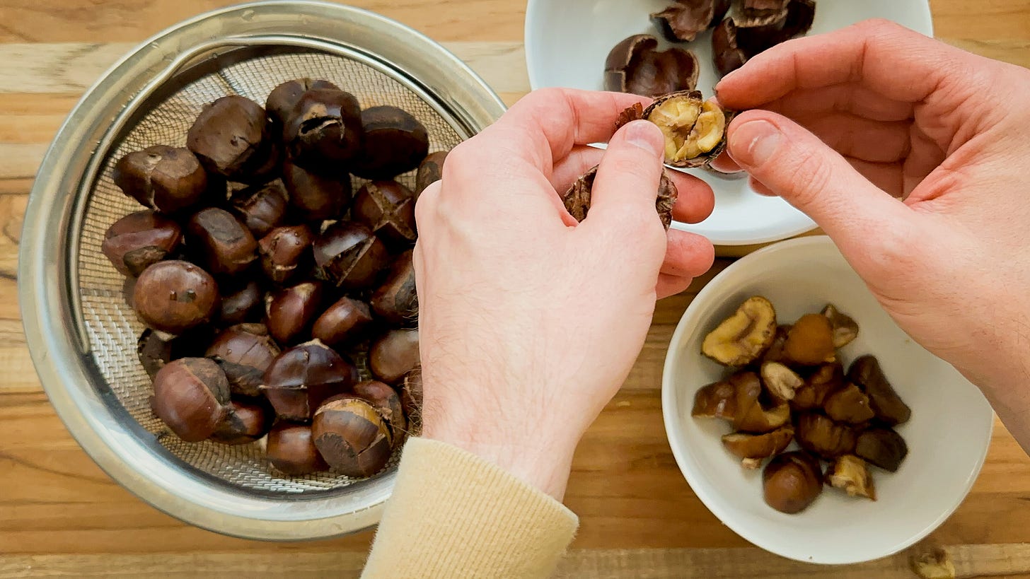 Photo of martin peeeling a basket of steamed chestnuts. 