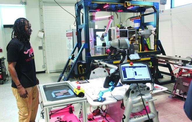 Valencia College Robotics and Semiconductor Training student Jermaine McCoy puts one of the training robots through its paces. PHOTO/KEN JACKSON