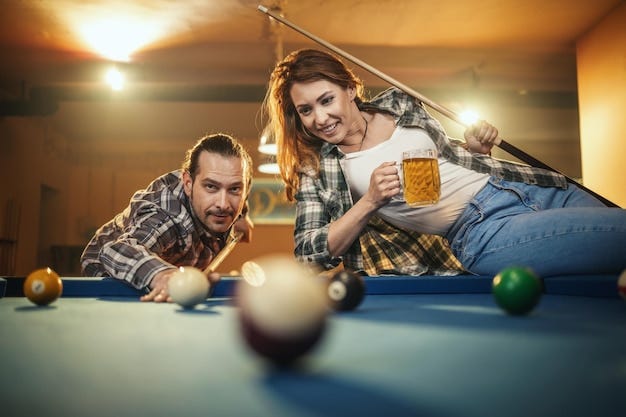 Young smiling cheerful couple is playing billiards in bar and drinking beer  after work. They are involved in recreational activity. | Premium Photo