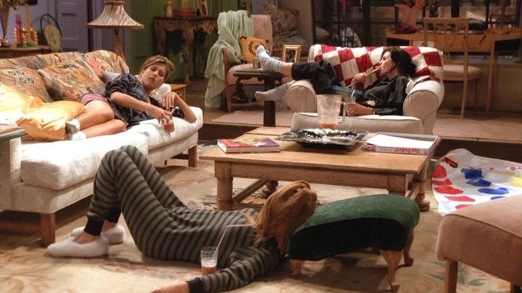 This may contain: three people sitting on couches in a living room with one person laying on the floor