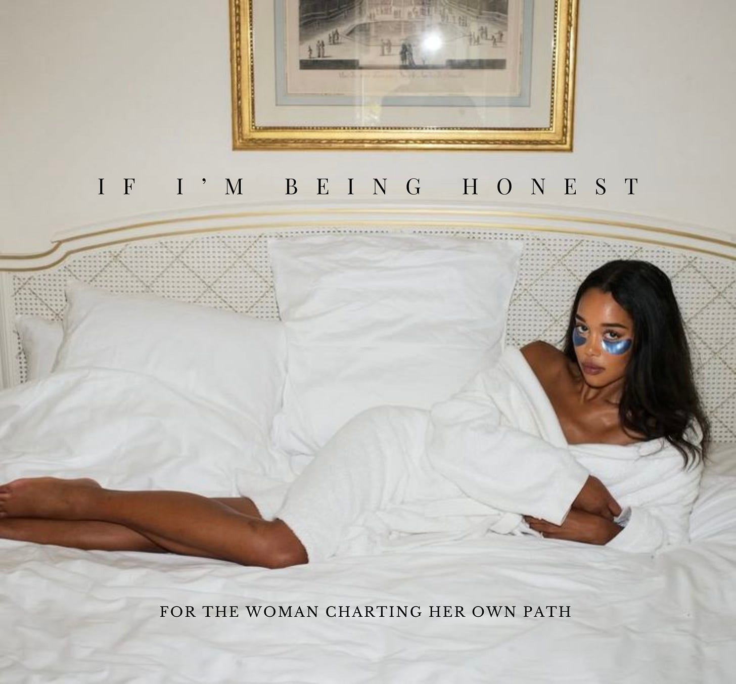 Laura Harrier lounging on the bed in a bath robe.