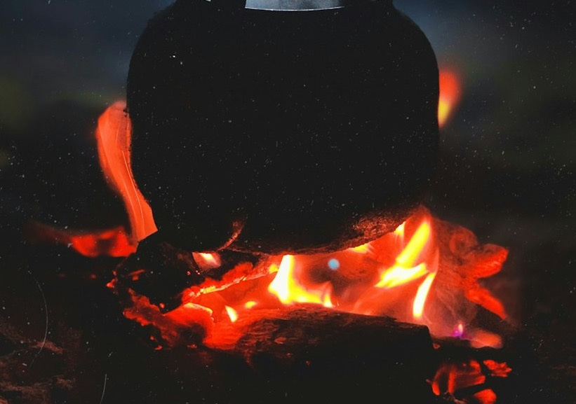 person in black hoodie standing on fire during nighttime