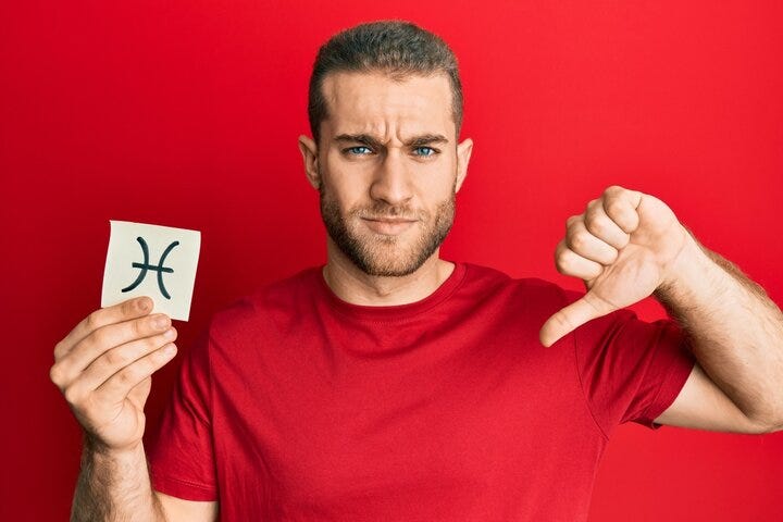 Young caucasian man holding paper with pisces zodiac sign with angry face, negative sign showing dislike with thumbs down, rejection concept
