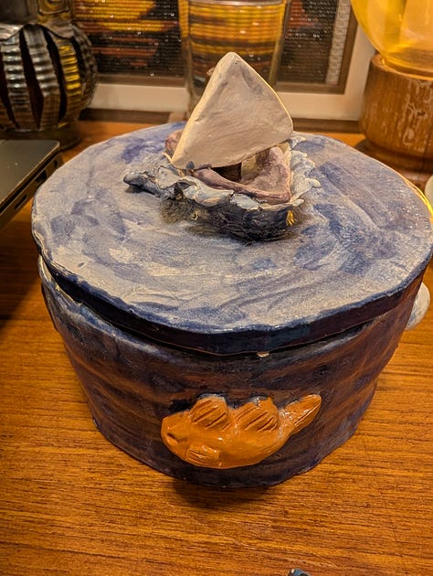 Three images of a blue ceramic container, hand-sculpted by Ahava.