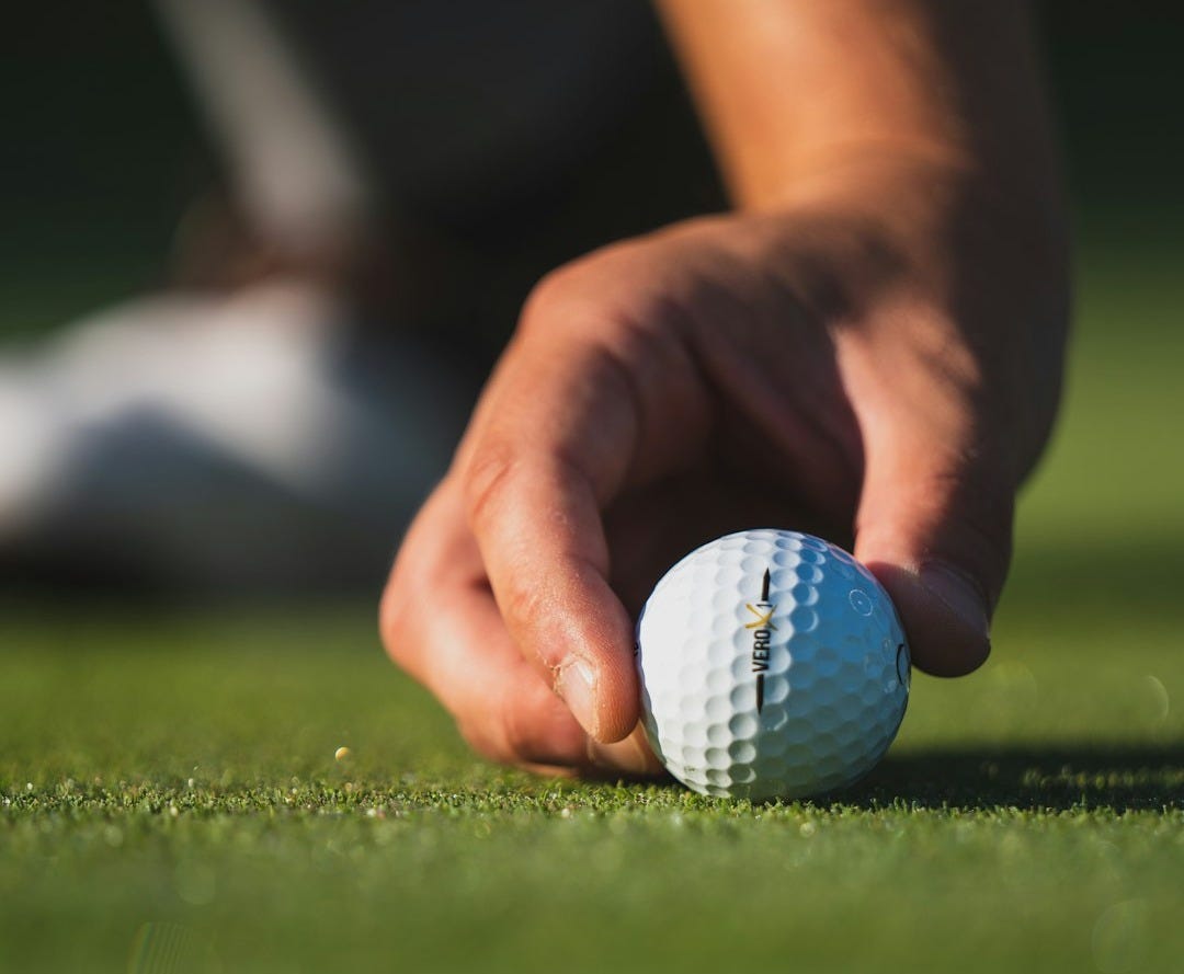white golf ball on green grass field white golf ball on green grass field