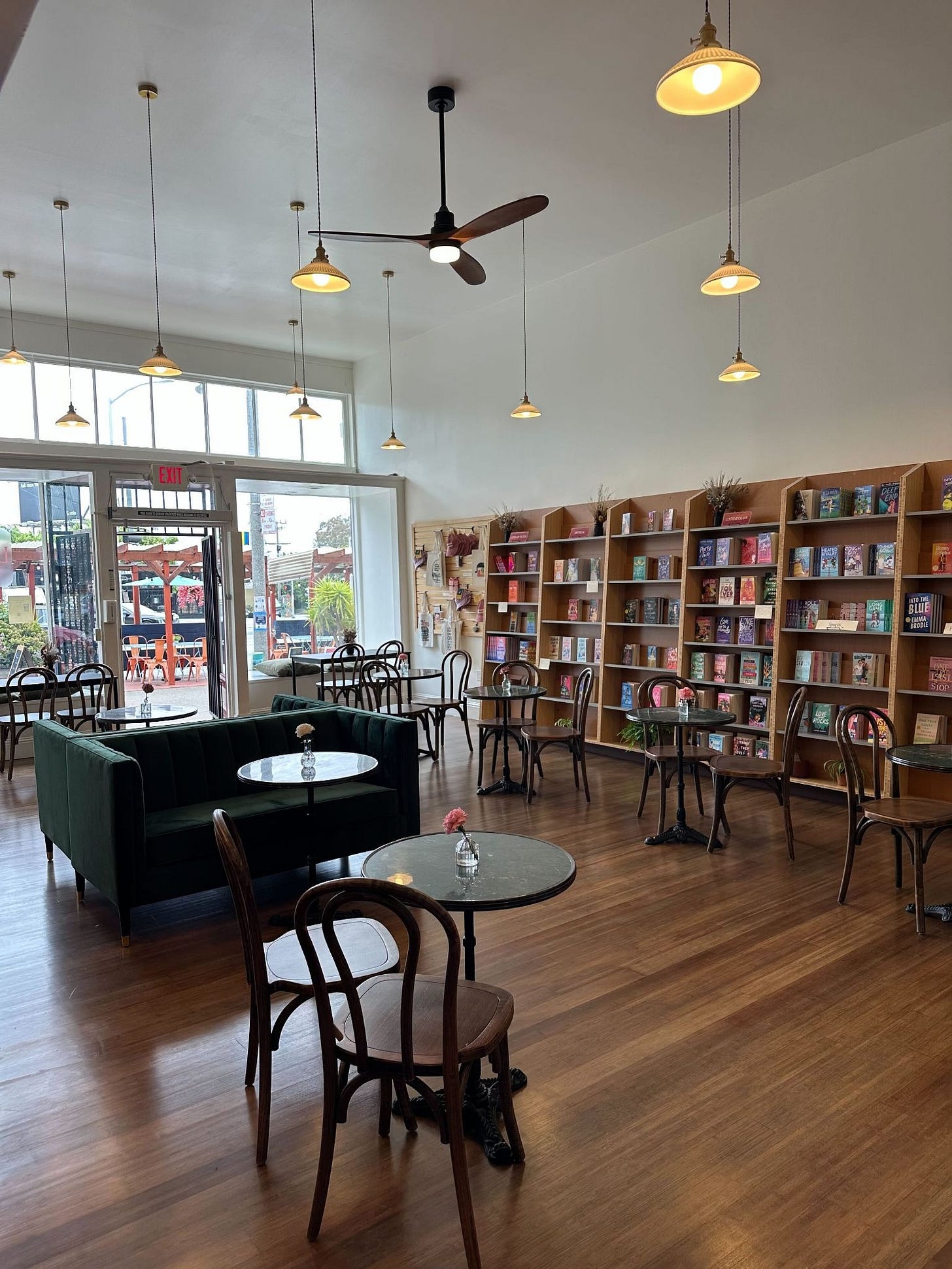 A bookstore's interior with shelves of books (face out) and cafe tables