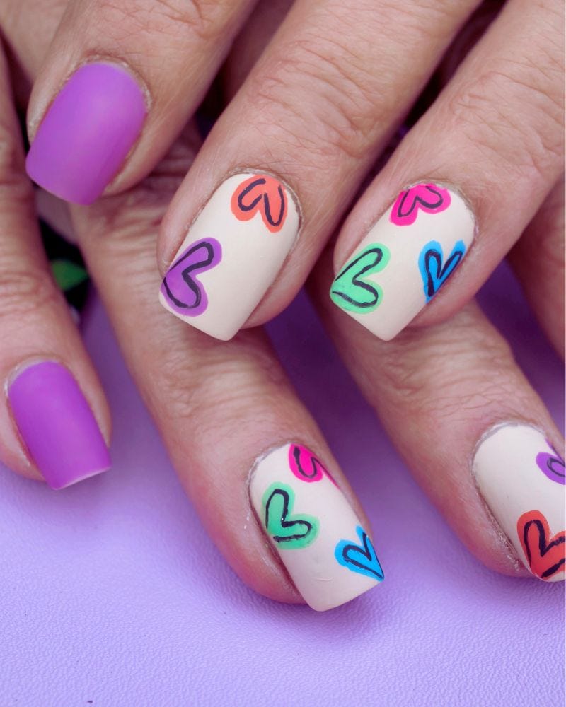 a close up of a painted fingernails using boho nail designs