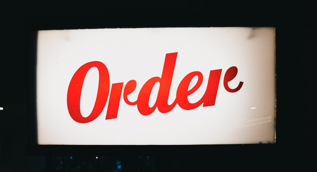 a red order sign hanging from the side of a building