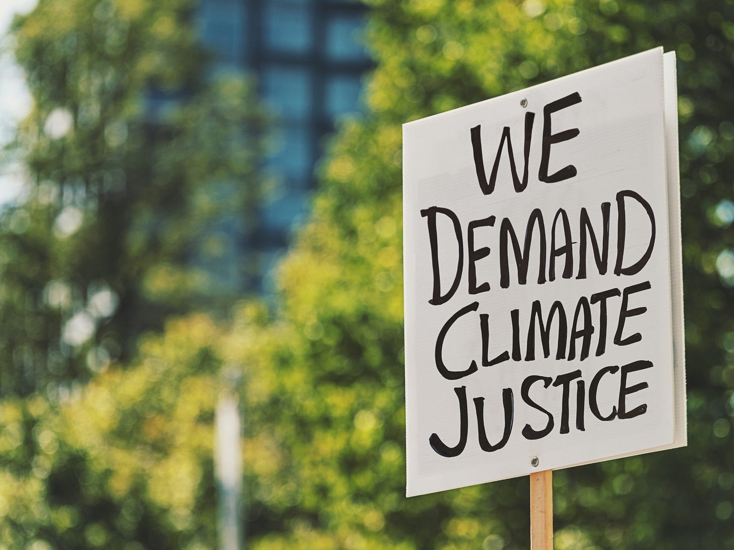 COP28: Protest over climate change. A board with 'We demand climate justice' written on it.
