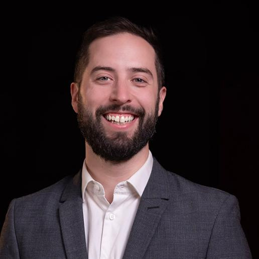 A person in a suit smiling

AI-generated content may be incorrect.