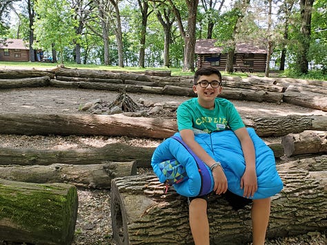 Posing with his cabin counselor and his riflery award