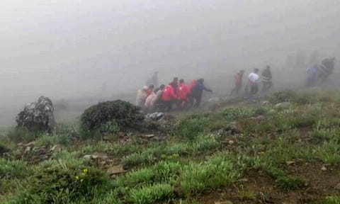 This grab taken from handout video footage released by the Iranian Red Crescent on 20 May shows rescuers recovering bodies at the site of the helicopter crash.