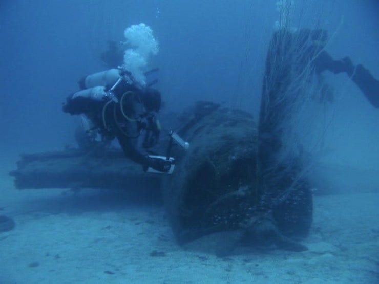 Diver Mike Waterfield filming a plane blown off the Saratoga's deck